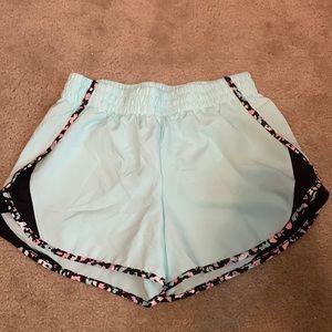 Teal athletic shorts , with black , white , pink , orange , and purple rim .